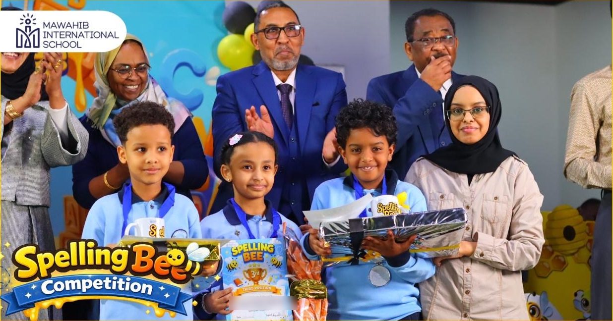 Young students holding their Spelling Bee prizes